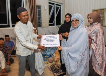 dr Susanti saat menyerahkan bantuan ke pengurus BKM Masjid Amalliyah.