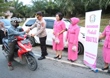 Kapolres Simalungun mendampingi kegiatan Ketua Bhayangkari Simalungun membagikan takjil jelang berbuka puasa di Jalan Parapat, Bah Sampuran, Kabupaten Simalungun. ( nawasenanews/ Ist)