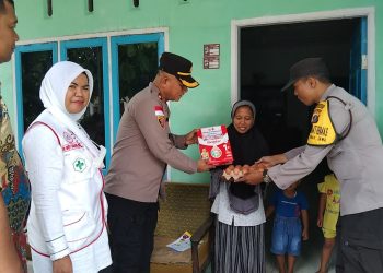 Kapolsek Tanah Jawa saat menyerahkan Pemberian Makanan Tambahan kepada anak untuk mencegah dan menangani Stunting.( nawasenanews/ Ist)