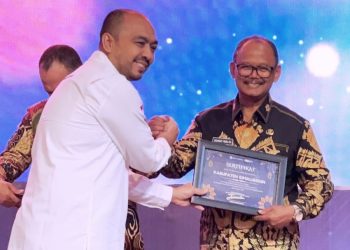 Wakil Bupati Simalungun Zonny Waldi saat menerima Award dari Bank Indonesia yang diserahkan Teuku Munandar di Medan.( nawasenanews.com/ Ist)