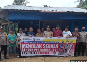 Polsek Parongil Polres Dairi bersama masyarakat membentangkan spanduk pernyataan menolak segala bentuk perjudian dan peredaran Narkoba. ( nawasenanews/ Ist)