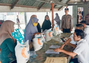 Personil Polres Tanjungbalai saat membantu mengamankan penyaluran bantuan pangan untuk warga agar pendistribusian lancar.( nawasenanews/ Ist)