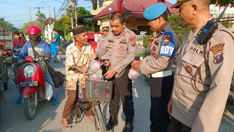 Wakapolres Tanjungbalai saat membagikan takjil gratis kepada salah seorang warga yang melintas di depan Mako Polres Tanjungbalai. ( nawasenanews/ Ist)