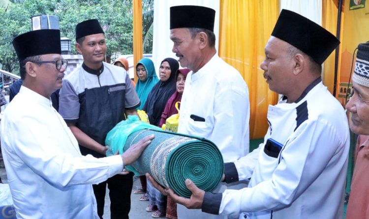 Wakil Bupati Simalungun saat menyerahkan sajadah panjang pada rangkaian Safari Ramadan dan Silaturahmi dengan masyarakat Kecamatan Bandar Huluan. (nawasenanews/ Ist)