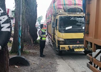 Kasat Lantas Polres Pematang Siantar saat menahan truk tiga sumbu yang melintas di Jalan Parapat Simarimbun.( Nawasenanews/ Ist)