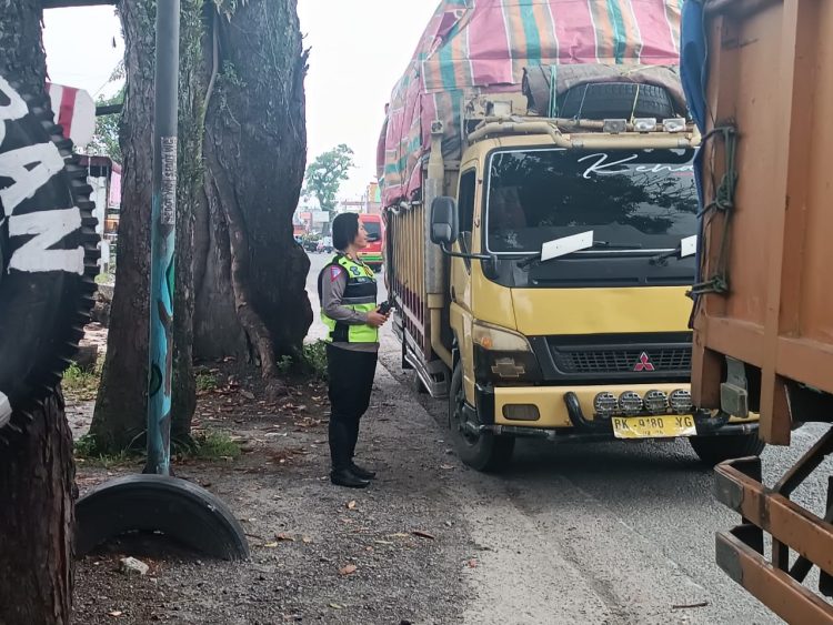 Kasat Lantas Polres Pematang Siantar saat menahan truk tiga sumbu yang melintas di Jalan Parapat Simarimbun.( Nawasenanews/ Ist)