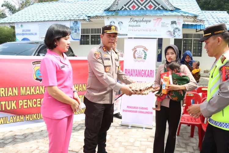 Kapolres didampingi Ketua Bhayangkari Kabupaten Simalungun memberikan makanan tambahan kepada salah satu anak asuh di Silau malaha. ( Nawasenanews/ Ist)