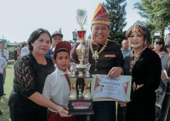 Bupati Dairi dan ketua TP PKK menyerahkan piala dan penghargaan kepada salah seorang anak sebagai pemenang di kejuaraan ISORI Cup X.(Nawasenanews/ Ist)