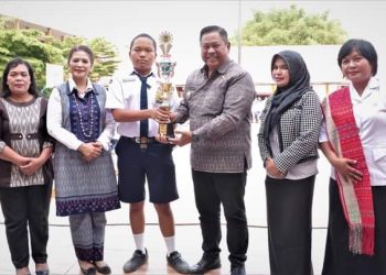 Bupati Dairi menyerahkan Piala kepada salah seorang siswa SMP Negeri 1 Sidikalang atas prestasi yang diraihnya.( Nawasenanews/ Ist)