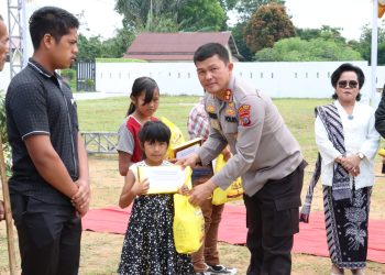 Kapolres Simalungun memberikan tali kasih kepada anak anak pada peringatan Paskah bersama Forkopimda dan Pemkab Simalungun di Tiga Runggu Kecamatan Purba.(Nawasenanews/Ist)