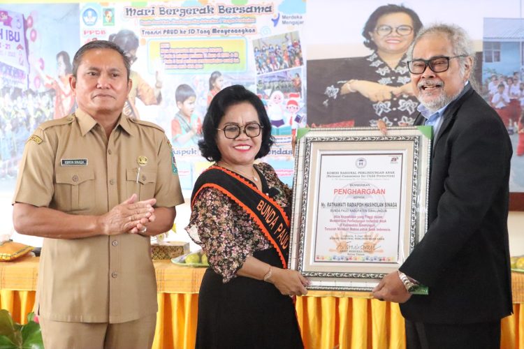 Bunda PAUD Ny. Ratnawati Radiapoh Hasiholan Sinaga menerima penghargaan dari Ketua Komnas PA atas perhatiannya kepada perkembangan anak anak di Simalungun.( Nawasenanews/ Ist)