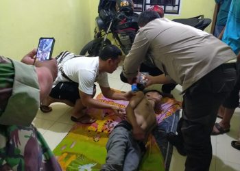 Personel Unit Reskrim Polsek Perdagangan saat mendokumentasikan korban bunuh diri usai diturunkan dari tali yang digunakan korban gantung diri, untuk kemudian dilakukan visum luar.(Nawasenanews/Ist)