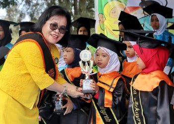 Bunda PAUD saat menyerahkan Tropy kepada siswa TKA yang diwisuda.( Nawasenanews/ Ist)