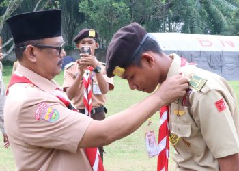 Kakwarcab Pramuka H Zonny Waldi saat memakaikan kacu pramuka ( hasduk) pada kerah pakaian pramuka salah seorang peserta Raimun ke XII, sebagai rangkaian acara dibukanya Raimuna XII. ( Nawasenanews/Ist)