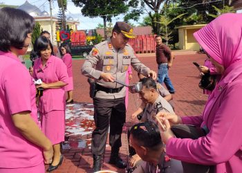 Kapolres Simalungun mengguyur air sebagai sebuah tradisi yang penuh makna kepada salah satu Bintara personel Polres Simalungun yang naik pangkat. ( Nawasenanews/ Ist)