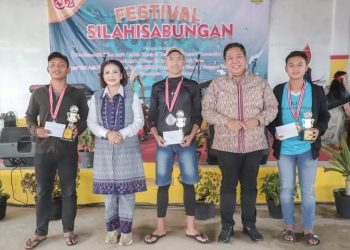 Bupati Dairi didampingi Ketua Dekranasda Dairi Romy Mariani Eddy Berutu memberikan tropy kepada para pemuda Silahisabungan yang menjadi penyelenggara acara Festival Silahisabungan.(Nawasenanews/Ist)