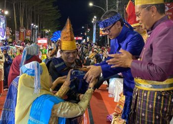 dr Susanti menyerahkan cenderamata pakaian adat Simalungun dan juga plakat Pemko Pematang Siantar kepada Ketua Dewan Pengurus APEKSI Bima Arya yang juga Wali Kota Bogor, dan Wali Kota Makassar Moh Ramdhan Pomanto selaku tuan rumah Rakernas APEKSI XVI Tahun 2023, di kawasan anjungan Pantai Losari Makassar.(Nawasenanews/ Ist)