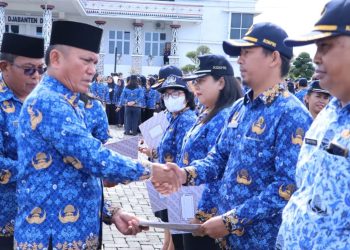 Sekda Esron Sinaga menyerahkan SK Pencantuman Gelar pada nama saat upacara Hari Kesadaran Nasional di kantor Bupati Simalungun di Pamatang Raya.( Nawasenanews/ Ist)