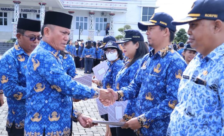 Sekda Esron Sinaga menyerahkan SK Pencantuman Gelar pada nama saat upacara Hari Kesadaran Nasional di kantor Bupati Simalungun di Pamatang Raya.( Nawasenanews/ Ist)