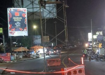 Petugas sedang memasang sensor ETLE di Simpang gerbang kota turis Parapat untuk menekan pelanggaran lalu lintas. (nawasenanews/Ist)