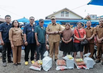 Bupati Dairi menyerahkan bantuan kepada korban kebakaran pasar Sidikalang Blok D3.