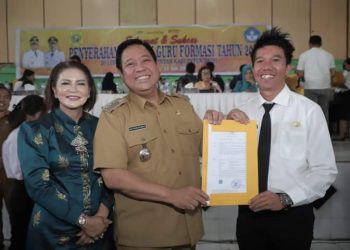 Salah seorang guru yang menerima SK P3K tersenyum lebar bersama Bupati Dairi dan Ketua TP PKK Dairi. (Nawasenanews.com/Ist)