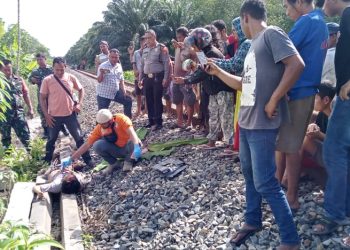 Inafis sedang melakukan visum luar terhadap korban tewas disenggol Kereta Api arah Medan di Sinaksak. ( Nawasenanews.com/ Ist)