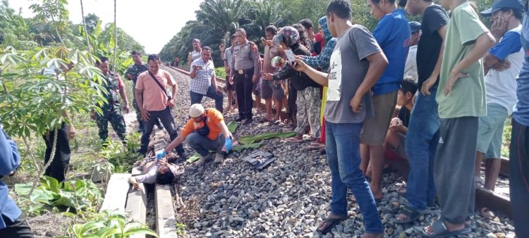 Inafis sedang melakukan visum luar terhadap korban tewas disenggol Kereta Api arah Medan di Sinaksak. ( Nawasenanews.com/ Ist)