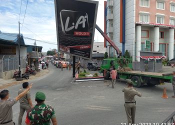 Satpol PP Pematang Siantar dengan tim terpadu merubuhkan papan reklame salah satu produk rokok yang tidak memiliki izin di dekat hotel Sapadia Jalan Diponegoro.(Nawasenanews.com/ Ist)