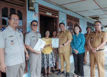 Bupati Dairi menyerahkan sertifikat tanah kepada salah satu warga desa Sitinjo sebagai hasil konsolidasi dengan warga untuk percepatan pembangunan dan nilai tambah bagi status tanah. ( Nawasenanews.com/ Ist)