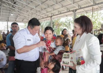 Bupati Dairi didampingi Ketua TP PKK Ny. Romy Simarmata Eddy Berutu saat memberikan bantuan untuk penanganan stunting kepada salah satu batita sambil mengajak bercanda.(Nawasenanews.com/ Ist).