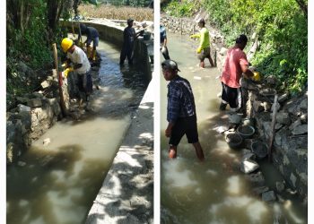 Keterangan Foto : Tukang saat mengerjakan pasangan batu padas pada aliran air yang mengalir.