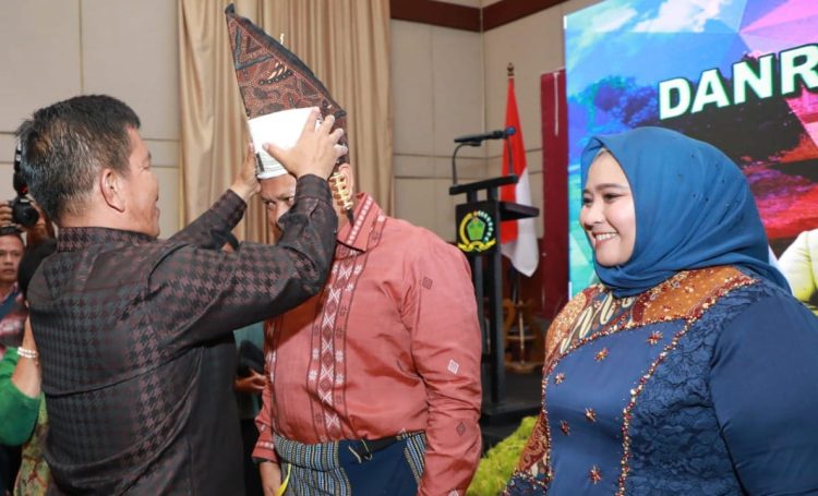 Bupati Simalungun memakaikan seperangkat pakaian adat Simalungun pada acara pisah sambut Danrem 022/ PT. ( Nawasenanews/ Ist)