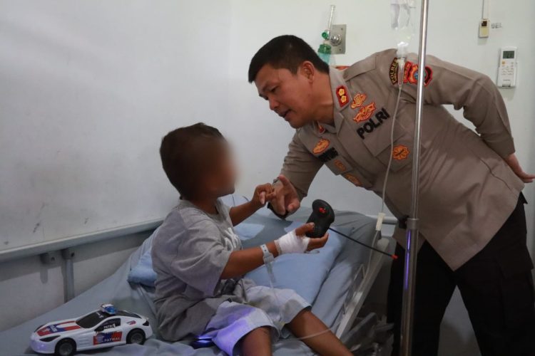 Kapolres Simalungun AKBP Ronald FC Sipayung membelikan bocah korban penganiayaan untuk menghibur dan menghilangkan trauma.( Nawasenanews/ Ist)