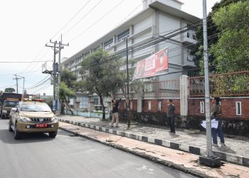 Petugas Satpol PP Kota Pematang Siantar sedang menurunkan spanduk caleg yang dipasang sebelum masa kampannye di Jalan Sangnaualuh Pematang Siantar sebagai upaya penertiban alat peraga kampanye.(Nawasenanews/ Ist)