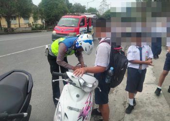 Keterangan Foto : Sat Lantas Pematang Siantar saat menindak tegas para pelajar yang nekat mengendarai kendaraan bermotor tidak menggunakan helm.(Ist)