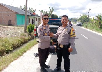 Bhabinkamtibmas Panei Bripka R Siahaan foto bersama dengan Kombes Pol.Hadi usai memperbaiki ban mobil. akibat insiden ban mobil dinas pejabat Polda Sumut itu pecah. ( Nawasenanews/ Ist)
