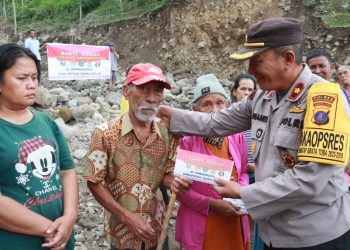 Wakapolres Simalungun Kompol Efianto saat menyerahkan bantuan dari Akabri secara simbolis kepada salah seorang warga korban banjir bandang di Haranggaol.(Nawasenanews/Ist)