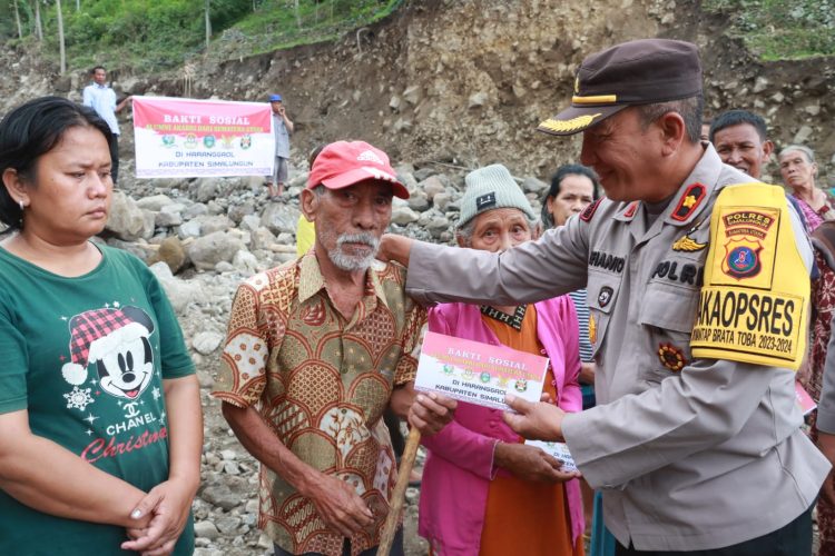 Wakapolres Simalungun Kompol Efianto saat menyerahkan bantuan dari Akabri secara simbolis kepada salah seorang warga korban banjir bandang di Haranggaol.(Nawasenanews/Ist)