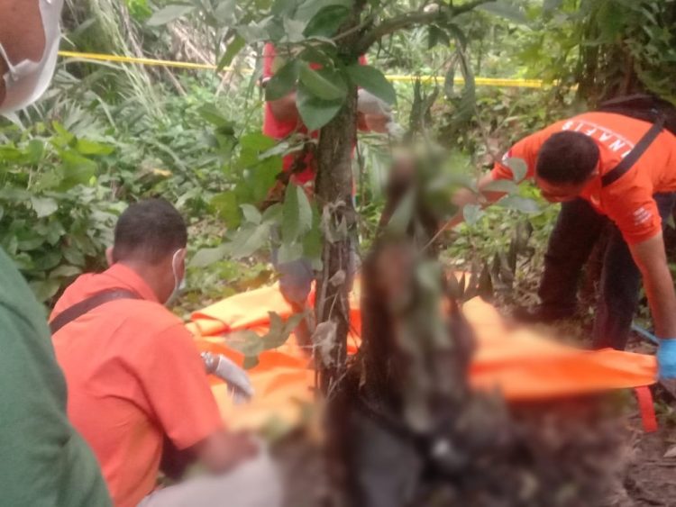 Petugas dari Polsek Perdagangan saat mengevakuasi jasad pensiunan BUMN yang ditemukan tewas tergantung di kebun sawit bu Eli di Huta III Nagori Perdagangan II Kecamatan Bandar. ( Nawasenanews/ Ist)