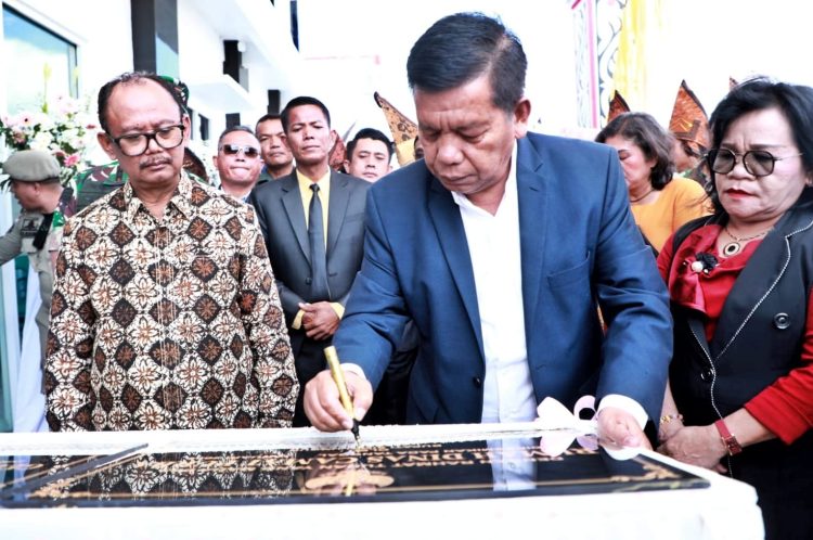 Keterangan Foto : Bupati Simalungun menandatangani prasasti saat peresmian kantor camat Purba.(Ist)