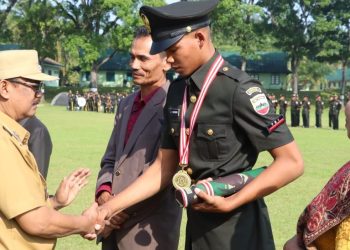 Wakil Bupati Simalungun memberi selamat kepada salah seorang Tamtama yang dilantik pada upacara penutupan Diktama gelombang II di Lapangan Rindam I/ BB Pematangsiantar.( Nawasenanews/ Ist)