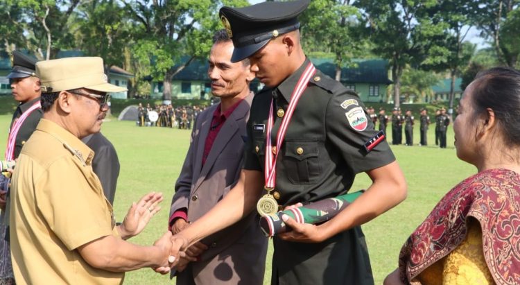 Wakil Bupati Simalungun memberi selamat kepada salah seorang Tamtama yang dilantik pada upacara penutupan Diktama gelombang II di Lapangan Rindam I/ BB Pematangsiantar.( Nawasenanews/ Ist)