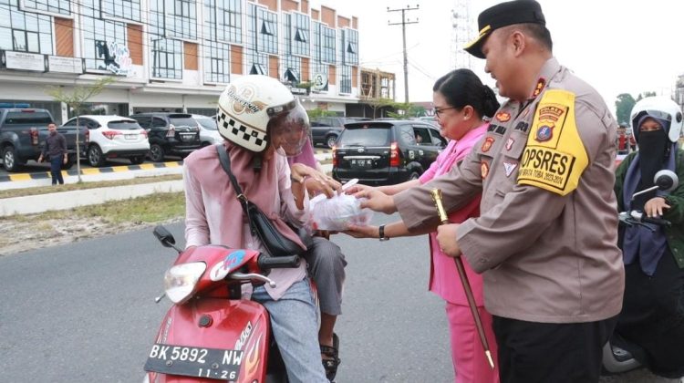 Kapolres Simalungun dan Ketua Bhayangkari Cabang Simalungun, Ny. Rina Choky Meliala saat membagikan takjil gratis di depan MUi Jalan asahan, Rabu (20/3/2024) sore. ( Nawasenanews/ Ist)