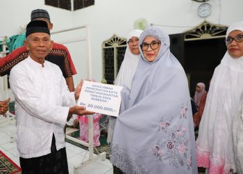 dr Susanti menyerahkan dana hibah Pemerintah Kota (Pemko) Pematangsiantar sebesar Rp20 juta kepada pengurus masjid Al- ikhlas yang diterima Ketua Badan Kenaziran Masjid (BKM) Al-Ikhlas Salin Purba SPdI.(Nawasenanews/Ist)