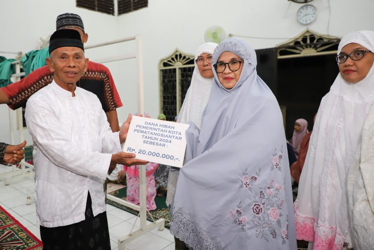 dr Susanti menyerahkan dana hibah Pemerintah Kota (Pemko) Pematangsiantar sebesar Rp20 juta kepada pengurus masjid Al- ikhlas yang diterima Ketua Badan Kenaziran Masjid (BKM) Al-Ikhlas Salin Purba SPdI.(Nawasenanews/Ist)