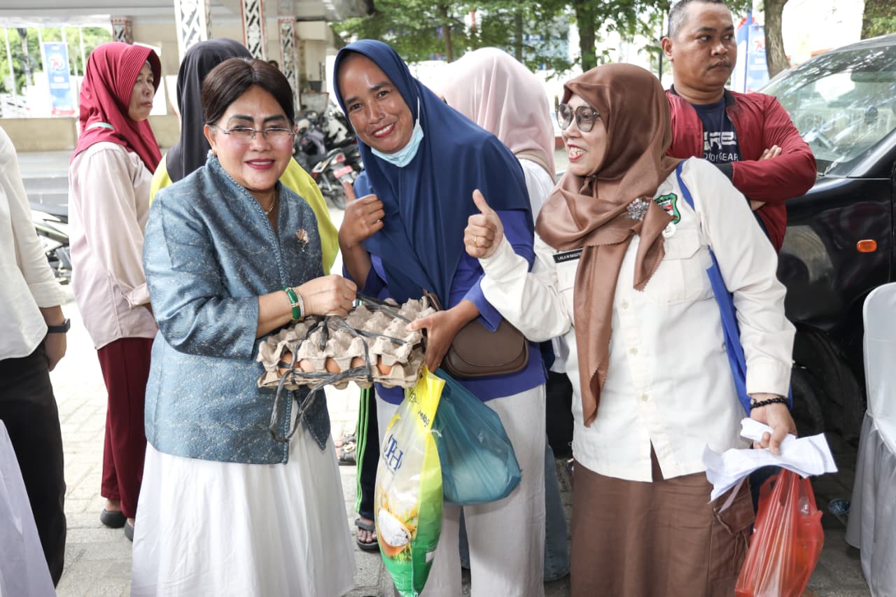 Seorang ibu yang membeli telur ayam di acara gerakan pangan murah berfoto bersama dengan Ketua PKK Kota Pematangsiantar.( Nawasenanews/Ist)