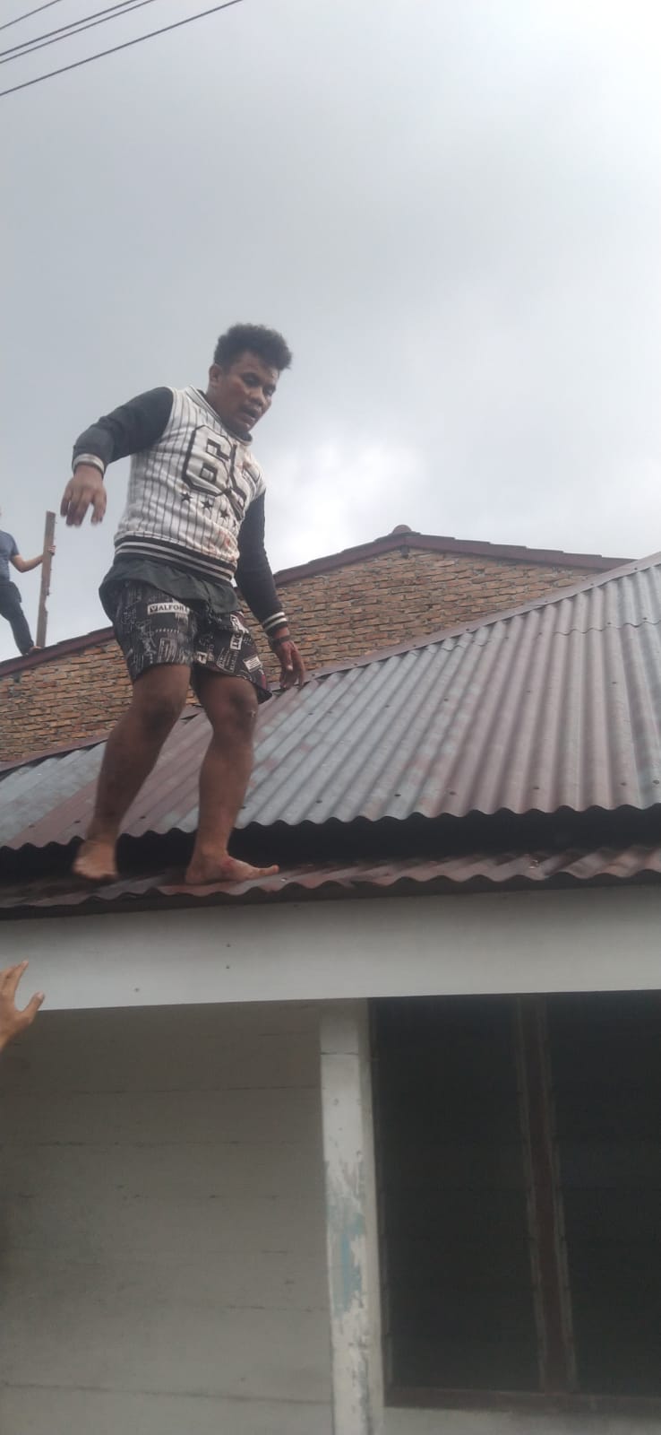 Tersangka Agus Zepa Tarihoran (25), warga Pematangsiantar, saat mencoba melarikan diri dari atas atap seng dan akhirnya ditangkap pada Senin, 06 April 2026, pukul 15.10 WIB di sebuah rumah kosong di Jalan Ksatria Lor 26, Kelurahan Siopat Suhu, Kecamatan Siantar Timur, Kota Pematangsiantar.( Nawasenanews/ Ist)